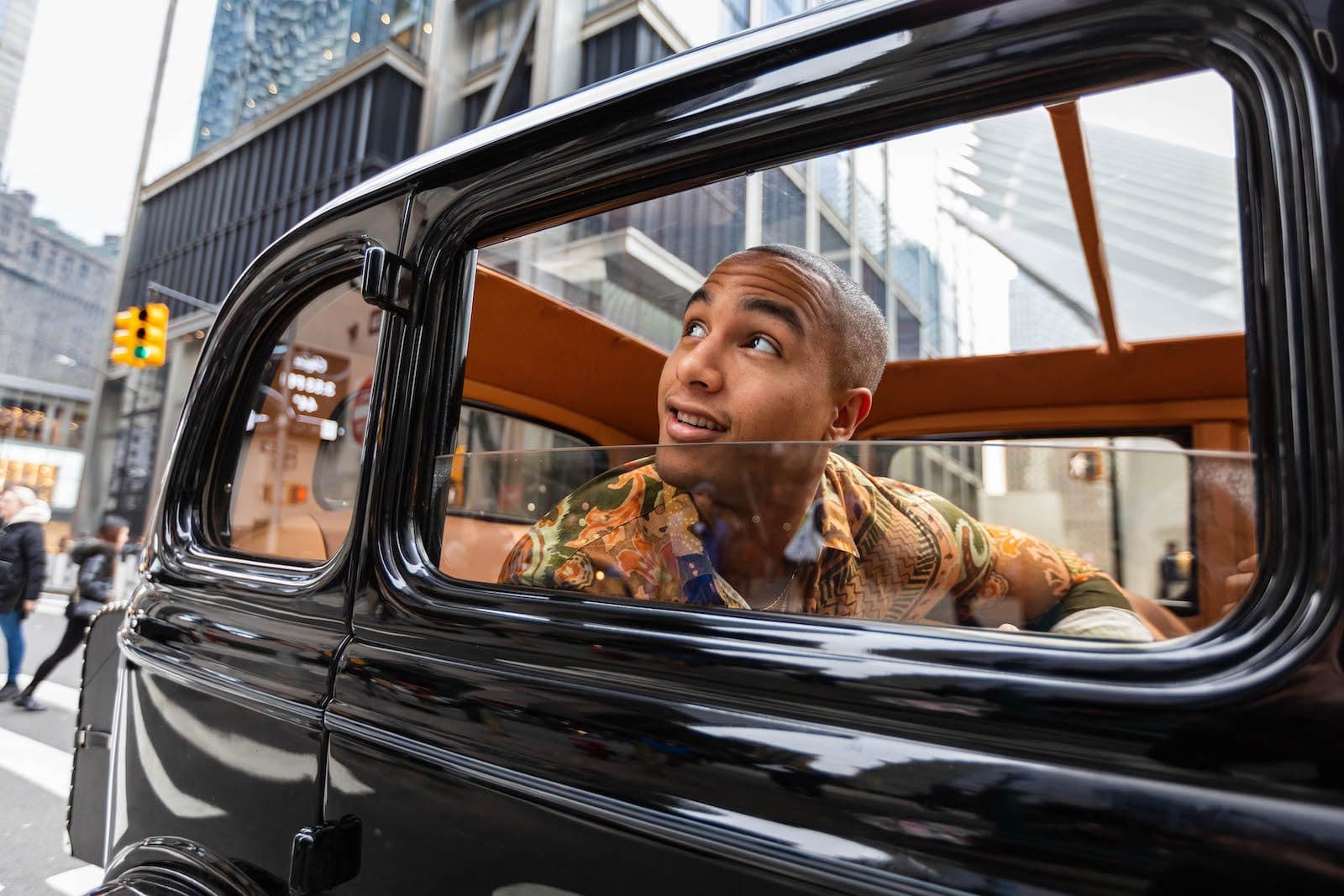 A guest looking out of a vintage car window in Midtown